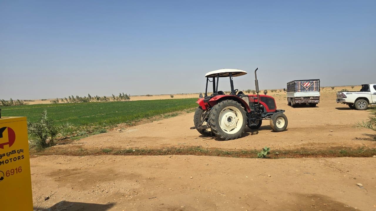 Agricultural tractor operating beside cultivated fields