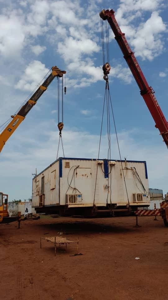 Two mobile cranes lifting a site module in a controlled operation