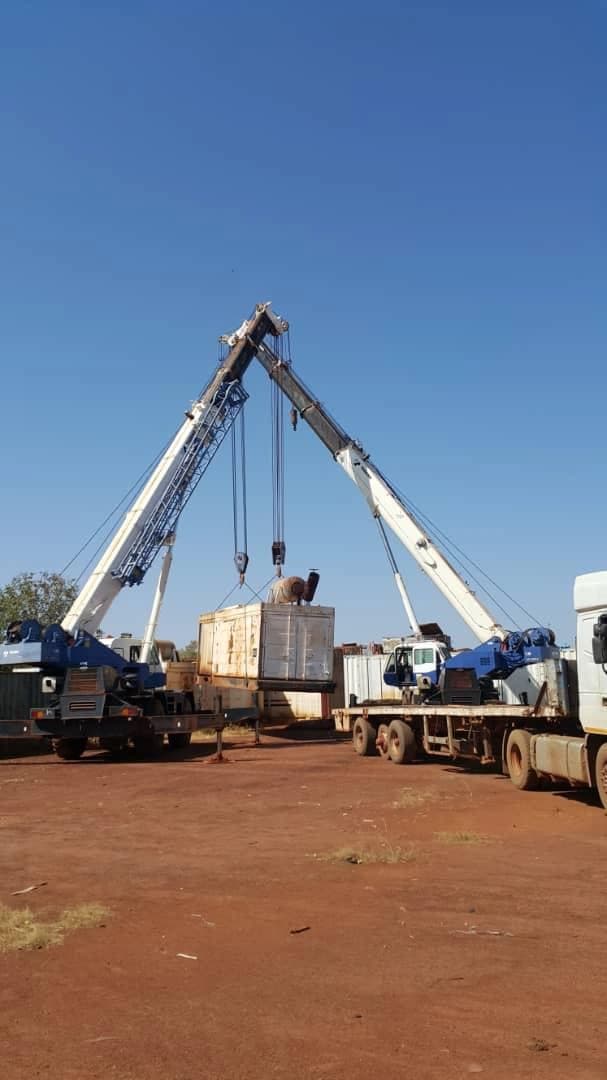 Two cranes coordinating the lift of a field module